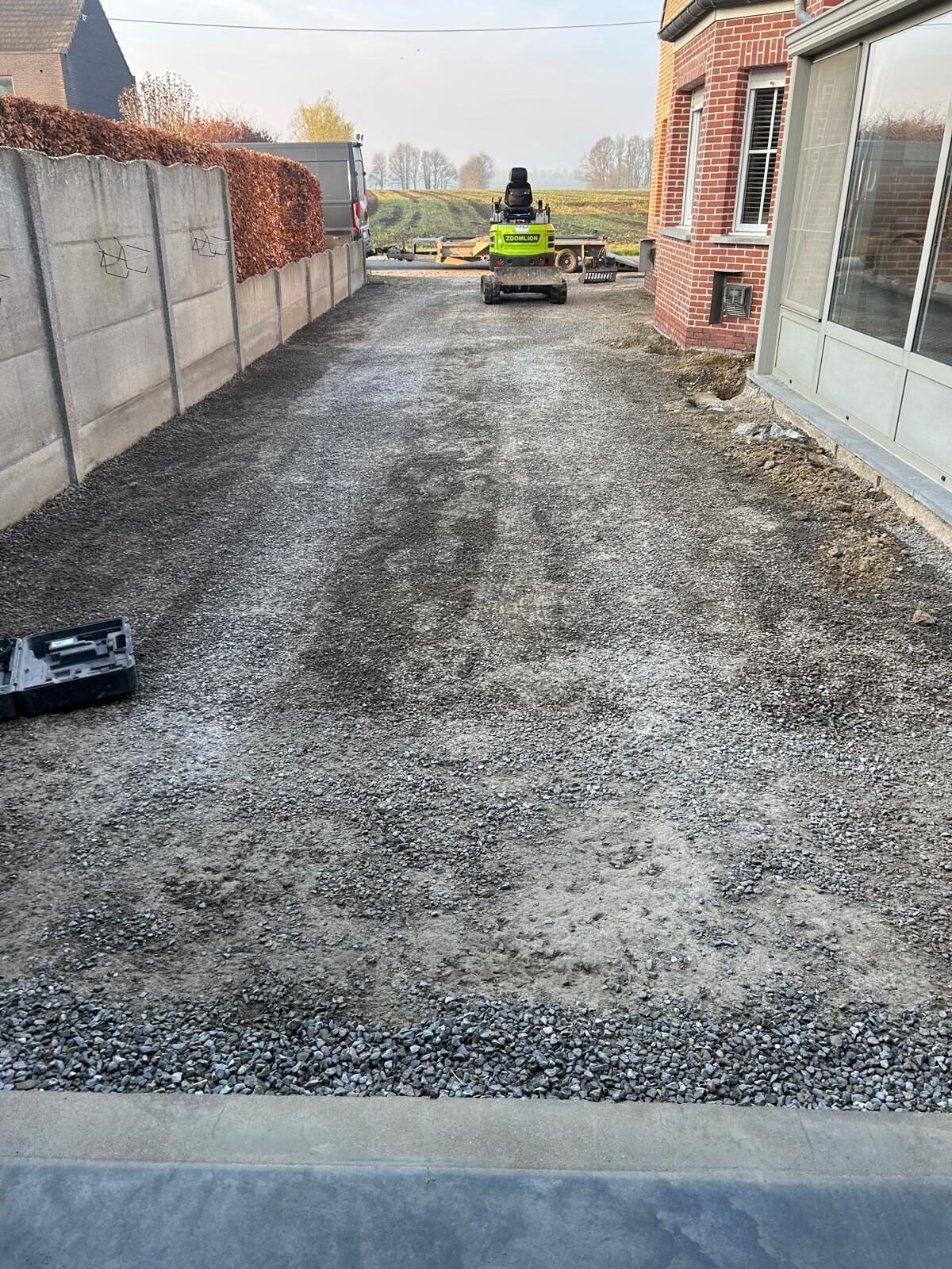 Oorspronkelijke staat van de oprit vóór de werken — uitgegraven en klaar voor fundering